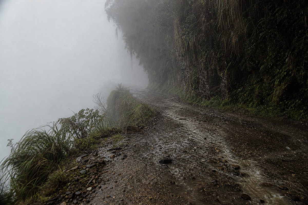 Fog and wet gravel covering the Death Road Bolivia route in the rainy season