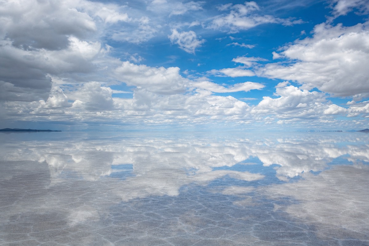 Mirror reflections on the flooded Uyuni salt flats at sunset, part of a Death Road and Uyuni combo trip in Bolivia